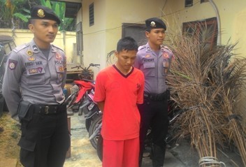 Tersangka dan barang bukti sawit yang sudah terbakar